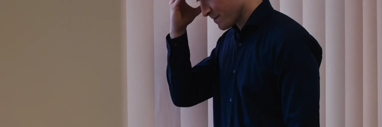 Pessoa olhando pela janela pensativa